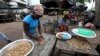 Des Ivoiriennes rassemblent des cacahuètes sur le marché local de Treichville, près d'Abidjan, le 2 novembre 2010.