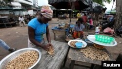 Des Ivoiriennes rassemblent des cacahuètes sur le marché local de Treichville, près d'Abidjan, le 2 novembre 2010.