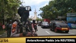 Petugas polisi bersenjata berjaga-jaga di sepanjang jalan tertutup menyusul ledakan di luar sebuah gereja Katolik di Makassar, Sulawesi Selatan, 28 Maret 2021. (Foto: Antara/Arnas Padda via REUTERS)