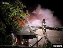 Los bomberos trabajan en el lugar de un edificio residencial dañado durante un ataque con aviones no tripulados rusos, en medio del ataque de Rusia a Ucrania, en la región de Kiev, Ucrania, el 31 de julio de 2024.