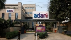 Seorang pria berjalan melewati kantor Adani Group di Gurugram, India, 22 November 2024. (Foto: Priyanshu Singh/Reuters)