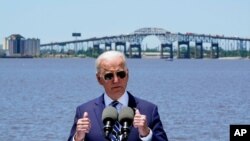 President Joe Biden speaks with the Interstate 10 Calcasieu River Bridge behind him, May 6, 2021, in Lake Charles, La. 