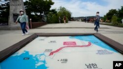 Visitors walk by a map of two Koreas showing North Korea's capital, Pyongyang, and South Korea's capital, Seoul, at the Imjingak Pavilion in Paju, near the border with North Korea, South Korea, Sept. 24, 2021.