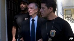 Carlos Nuzman, President of the Brazilian Olympic Committee, center, is escorted by federal police officers after being taken into custody at his home, in Rio de Janeiro, Brazil, Oct. 5, 2017.