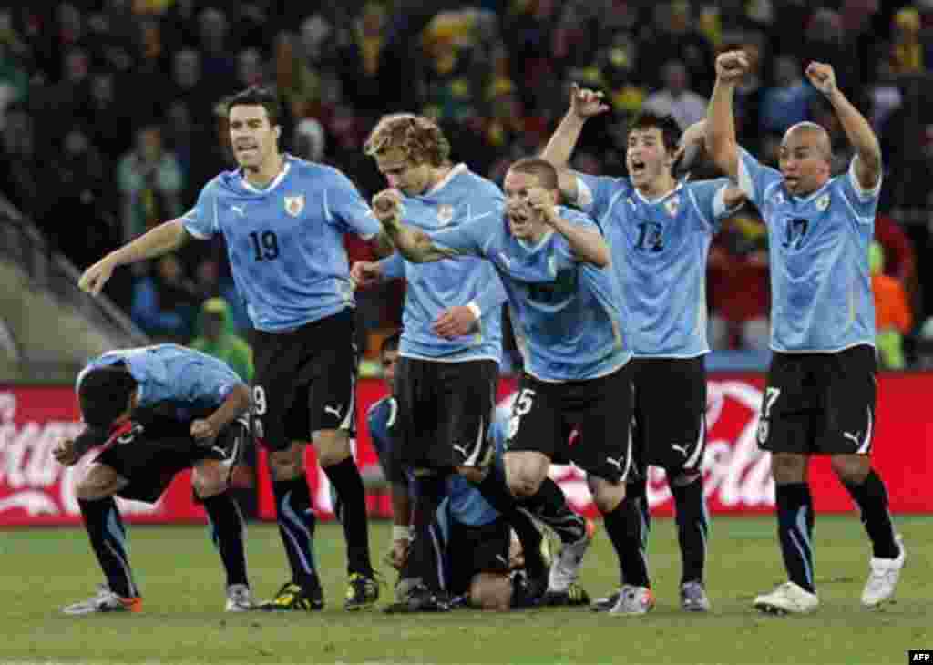 Uruguayan players celebrate after Ghana's Dominic Adiyiah missed a shootout penalty during the World Cup quarterfinal soccer match between Uruguay and Ghana at Soccer City in Johannesburg, South Africa, Friday, July 2, 2010. Uruguay reached the World Cup