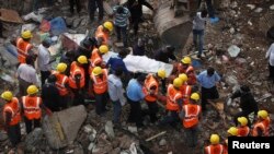 Rescue workers recover body from debris on site of a collapsed residential building, Mumbai, Sept. 28, 2013.