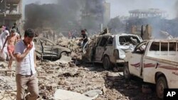 In this photo released by the Syrian official news agency SANA, Syrians inspect damages after twin bombings struck Kurdish town of Qamishli, Syria, July 27, 2016. 