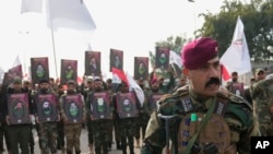 FILE - Members of an Iraqi Shiite militant group attend a funeral for group members killed by a U.S. airstrike, in Baghdad, Feb. 4, 2024. In February, the U.S. struck 85-plus targets in Iraq and Syria linked to Iran's Islamic Revolutionary Guard Corps.