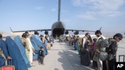 24일 아프가니스탄 카불 국제공항에서 탈레반 점령을 피해 아프가니스탄을 탈출하는 사람들이 미 공군 수송기에 오르고 있다.