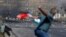 Un manifestant palestinien lance une pierre en direction des forces israéliennes lors d'affrontements près de la colonie juive de Beit El, près de Ramallah, en Cisjordanie occupée, le 14 mai 2021.