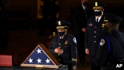 FILE - Acting U.S. Capitol Police Chief Yogananda Pittman pays respects to Officer Brian Sicknick as an urn with his cremains lies in honor in the Capitol Rotunda, Feb. 2, 2021, in Washington. 