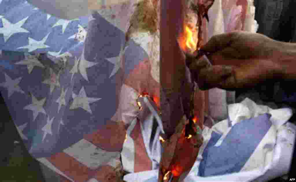 A Palestinian supporter of Islamic Jihad burns an American flag in protest during a demonstration marking the 2nd anniversary of the Israel-Gaza war, in the Jebaliya refugee camp, northern Gaza Strip, Monday, Dec. 27, 2010. Israel's volatile front with Ga