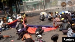 Protesters crouch after police opened fire to disperse an anti-coup protest in Mandalay, Myanmar, March 3, 2021. Among them, Angel, 19, left, also known as Kyal Sin, took cover before she was shot in the head. (REUTERS/Stringer)