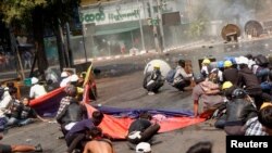 Protesters crouch after police opened fire to disperse an anti-coup protest in Mandalay, Myanmar, March 3, 2021. Among them, Angel, 19, left, also known as Kyal Sin, took cover before she was shot in the head. (REUTERS/Stringer)