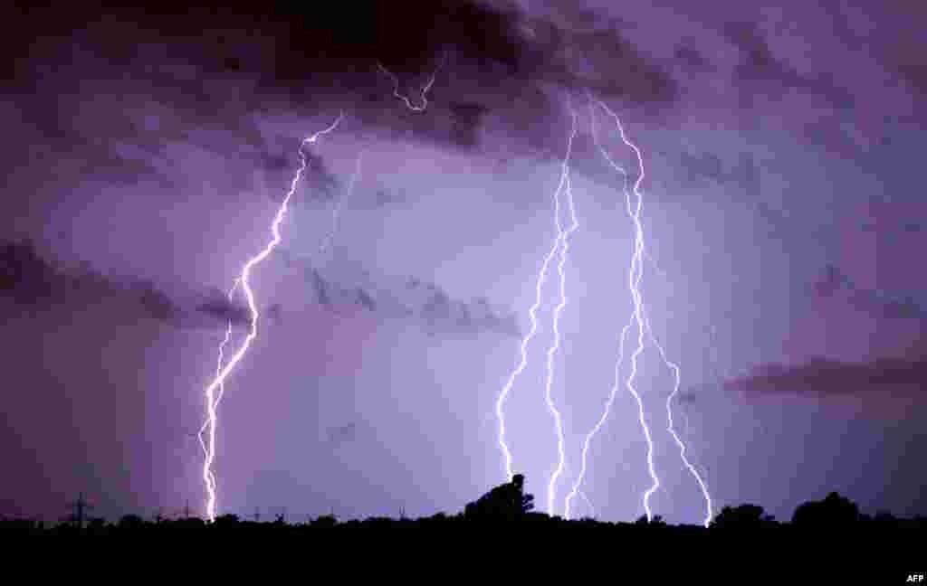 Lightning over Algermissen, Germany. Violent storms killed at least six people in western Germany overnight, felling trees and snarling road and rail traffic, authorities said.