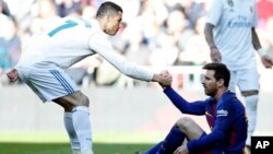 Cristiano Ronaldo aidant Lionel Messi à se relever lors du classico en Liga, Madrid, 23 décembre 2017.