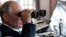 FILE - Russian President Vladimir Putin holds binoculars while watching military exercises at "Telemba" training ground about 80 kilometers (50 miles) north of the city of Chita in eastern Siberia, Russia, Sept. 13, 2018. 