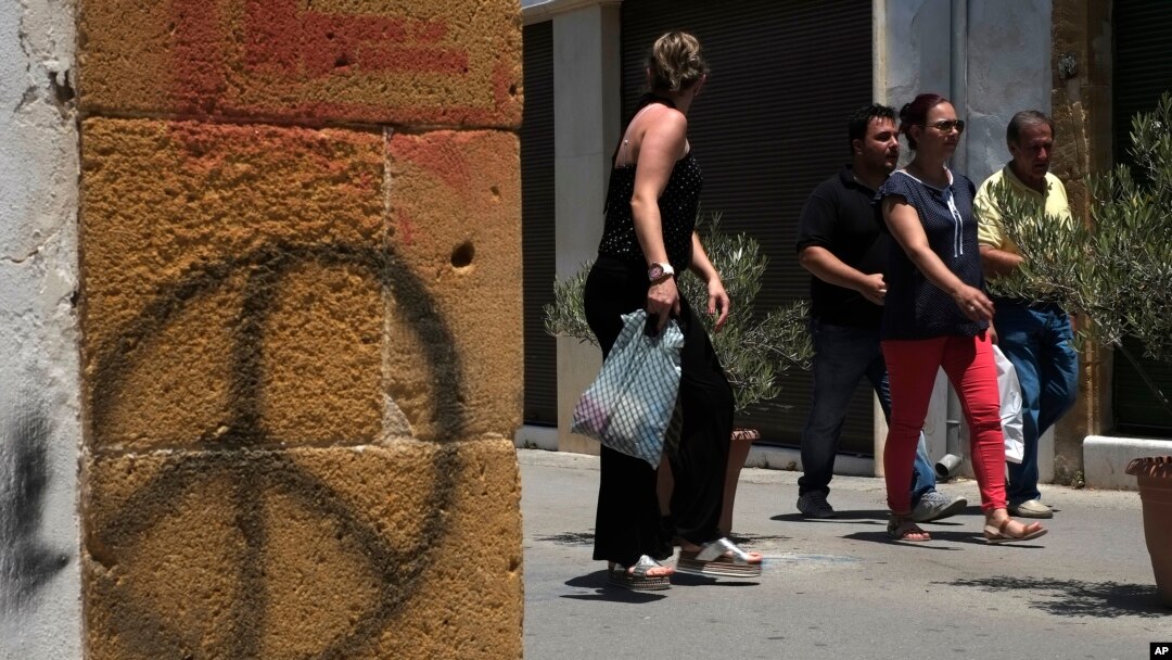 People cross the Ledra street crossing point that leads from the north to the south between the U.N buffer zone in the divided capital Nicosia, Cyprus, June 28, 2017. 