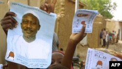 Des affiches d’Ibni Oumar Mahamat Saleh brandies avant un meeting au stade de Ndjamena, le 17 mai 2001. 