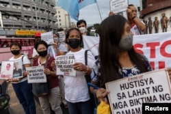 Kerabat korban perang narkoba memegang plakat menyerukan keadilan dalam pawai solidaritas setelah Pengadilan Kriminal Internasional (ICC) memutuskan untuk melanjutkan penyelidikan pembunuhan perang narkoba di Filipina, di Quezon City, Filipina, 18 Juli 2023. (REUTERS/Eloisa Lopez)