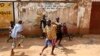 FILE - Children play in the street in Kisenyi, a slum in Kampala.