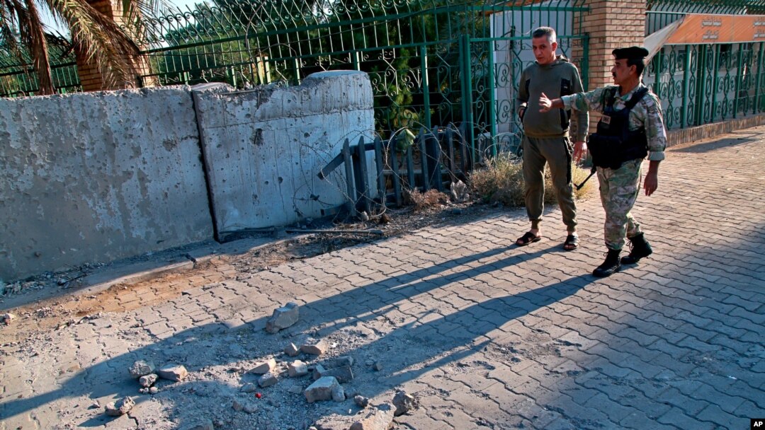 Security forces inspect the scene of a rocket attack at the gate of al-Zawra public park in Baghdad, Iraq, Nov. 18, 2020. Rockets struck Iraq's capital on Tuesday with four landing inside its heavily fortified Green Zone.
