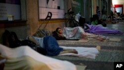 Homeless people sleep outside the public defenders office in Rio de Janeiro, Brazil, Dec. 6, 2017.