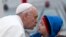 Pope Francis reaches out to kiss a child as he arrives to the Aparecida Basilicia in Aparecida, Brazil, July 24, 2013.