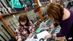 Andrea Schry, a la derecha, llena los formularios de venta de armas en un comercio de New Castle, Pensilvania, el 25 de marzo de 2020.