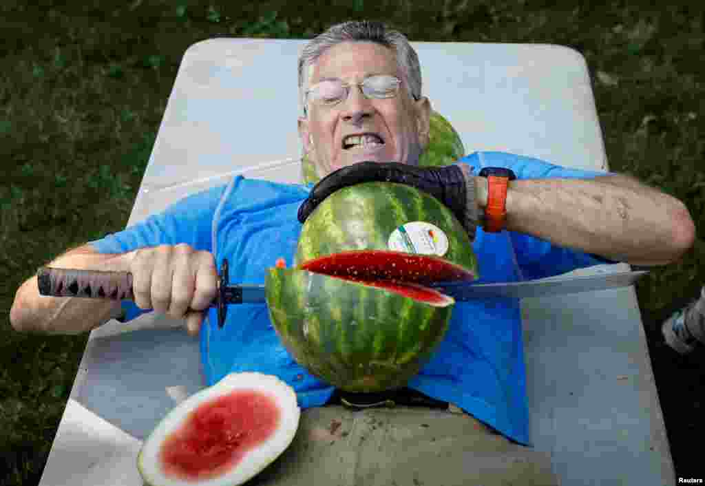 Ashrita Furman, who holds more Guinness World Records than anyone, attempts to set a new record for slicing the most watermelons in half on his own stomach in one minute in New York City, July 17, 2018.