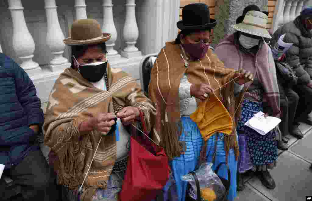 Women knit while waiting for the AstraZeneca vaccine for COVID-19 at a government-run social security clinic during vaccinations for people over age 80 in La Paz, Bolivia.