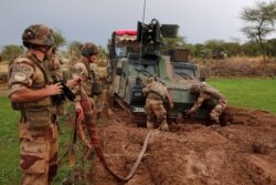 French soldiers of the "Belleface" Desert Tactical Group (GTD) try to move an all terrain armored vehicle from the mud in the Gourma region during Operation Barkhane in Ndaki, Mali, July 28, 2019.