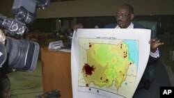 Director of the Sudanese Survey Authority Prof. Ahmad Al-Sadiq displays a new map of the country of Sudan, announced by the Sudanese Ministry of Information in Khartoum, July 4, 2011