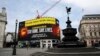 Layar video menampilkan pesan untuk masyarakat agar tetap tinggal di rumah untuk menghambat penyebaran virus corona, di Piccadilly Circus, London, 8 April 2020. 