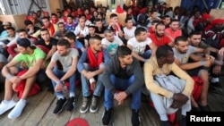 FILE - Migrants wait to disembark from the Vos Hestia ship as they arrives in the Crotone, Italy, after being rescued by a Save the Children crew in the Mediterranean sea off the Libya coast, June 21, 2017. 