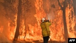 A firefighter conducts back-burning measures to secure residential areas from encroaching bushfires in the Central Coast, some 90-110 kilometers north of Sydney, Australia.