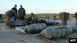 Libyan soldiers loyal to Libya's internationally recognized government work next to bombs at the Benina air base on Dec. 10, 2015, south of the eastern coastal city of Benghazi. 