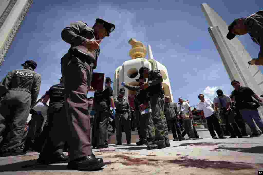 Thai police investigate following an overnight shooting attack at Democracy Monument in Bangkok, Thailand, Thursday, May 15, 2014. Explosions and an overnight shooting attack on opposition demonstrators in Thailand's capital killed at least two people Thu