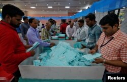 Election staff members sort ballot papers before counting them inside a vote counting center in Ahmedabad, India, May 23, 2019.