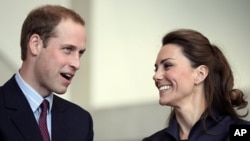 Britain's Prince William speaks, watched by his fiancee Kate Middleton at the Darwen Aldridge Community Academy, in Darwen, northern England, April 11, 2011