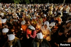 FILE - Sikhs and members of the community attend a vigil for the victims who were fatally shot by a white supremacist, in Oak Creek, Wisconsin, Aug. 7, 2012.