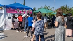 People wait in line to buy food outside food tents during the reopening of the Wat Thai (Thai Temple) of Los Angeles Food Court