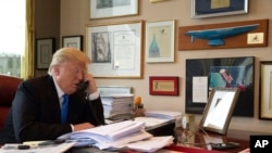 Republican presidential candidate Donald Trump takes a telephone call from his daughter Ivanka during an interview with The Associated Press in his office at Trump Tower, Tuesday, May 10, 2016, in New York.