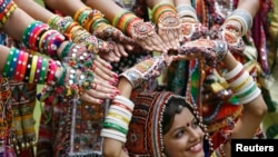 A girl dressed in traditional attire poses as she takes part in rehearsals for the "garba" dance ahead of Navratri festival in the western Indian city of Ahmedabad, Sept. 29, 2013.