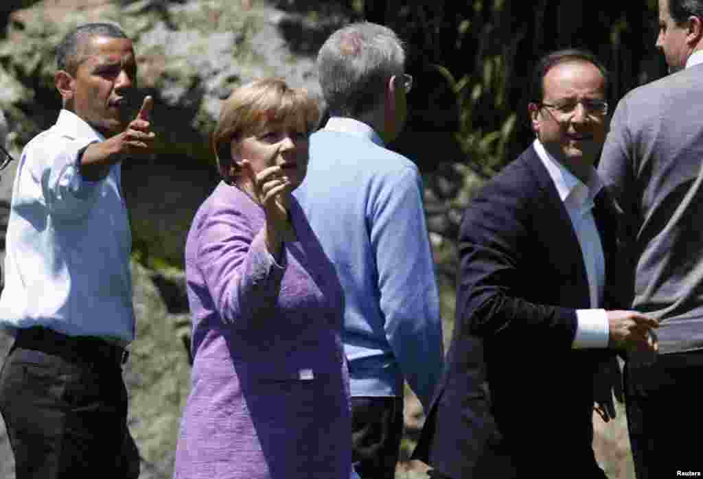 U.S. President Barack Obama, Germany's Chancellor Angela Merkel and French President Francois Hollande (L to R) face the media as the G8 leaders gather for a family photo at the G8 Summit at Camp David, Maryland, May 19, 2012