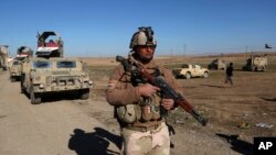 Abasirikare ba Iraki inyuma y'aho bakuriye Umuhari wa Reta ya Kiyisilamu m'Ubuseruko bwa Mosul. Ukwezi kwa mbere. 24, 2017.