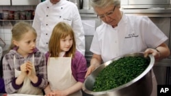 In this file photo, Annette Schavan, right, German Minister for Education prepare a kale dish together with children in Oldenburg, northern Germany, March 16, 2010. (apn Photo/Focke Strangmann)