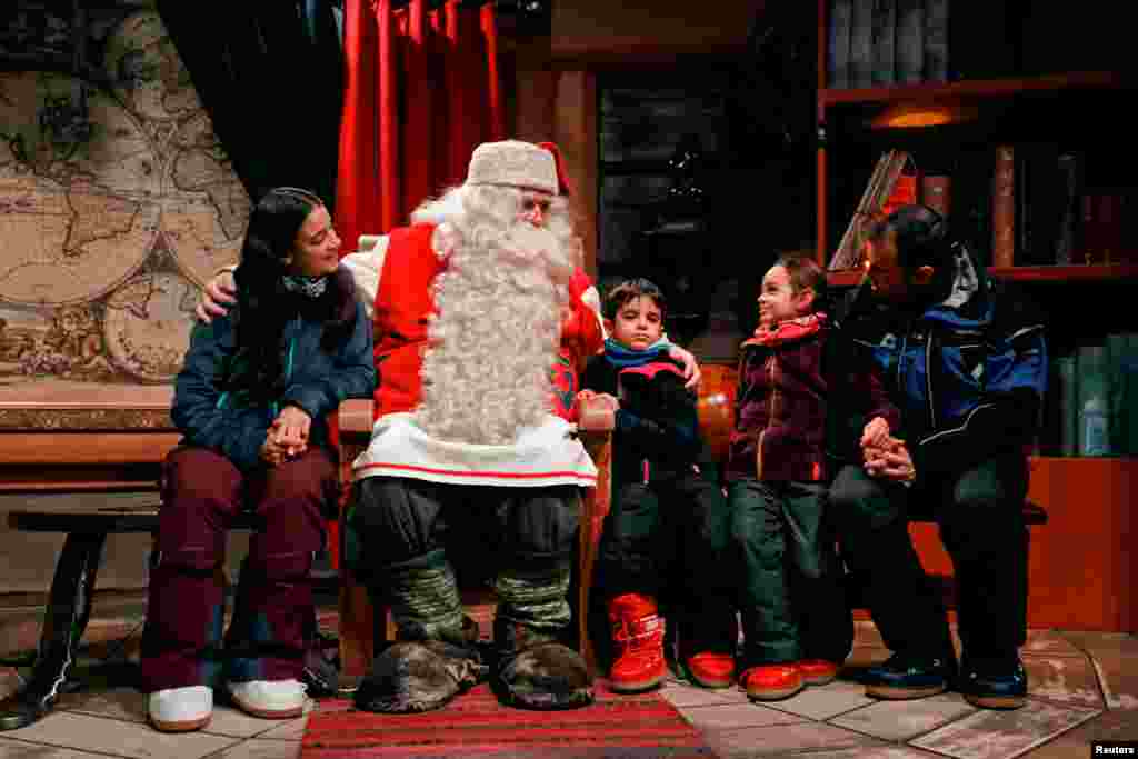 Children around the world visit Santa. In this image, Santa Claus talks to the Caballero family from Itay at Santa Claus&#39; Village.