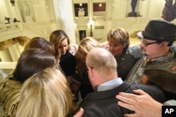 FILE - Survivors of child sexual abuse hug in the Pennsylvania Capitol while awaiting legislation to respond to a landmark state grand jury report on child sexual abuse in the Roman Catholic Church, in Harrisburg, Pa., Oct. 17, 2018.