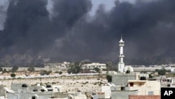 Smoke rises above downtown Tripoli following fighting at Bab Al-Aziziya compound August 23, 2011